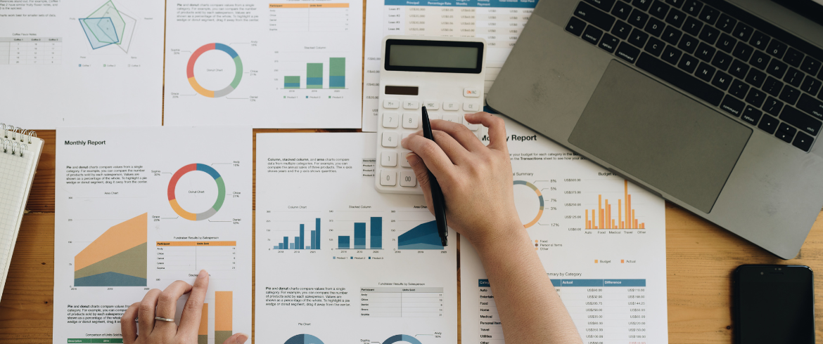 A person reviewing paper documents that show company traction based on financial and fractional marketing data.